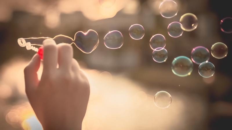 une-main-qui-fait-des-bulles-avec-une-bulle-en-forme-de-coeur